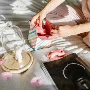 A person unboxes a gift among pink petals, promoting elegance and luxury.